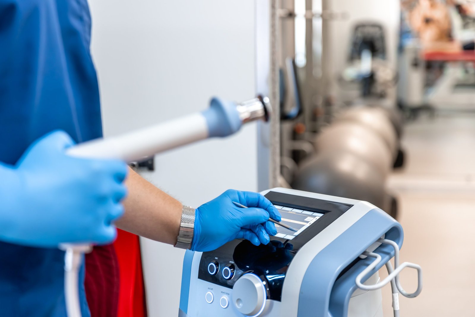 shock wave therapy device with male doctor hands rubber gloves scaled